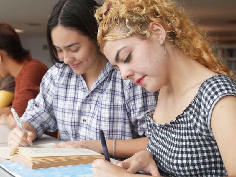 dve devojke zapisuju na fakultetu podatke u svesku