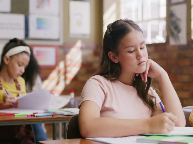 devojčice u školi sede i čitaju