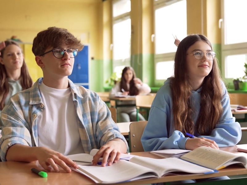 grupa đaka sedi u pkolskim klupama